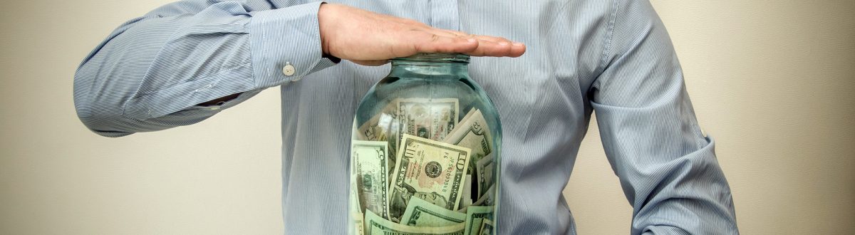 Man with tie saving money in a jar
